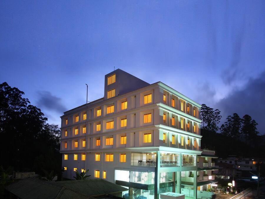Un hotel de varios pisos con ventanas iluminadas y un diseño arquitectónico moderno.
