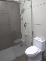 Un baño con ducha de vidrio, inodoro y bidé.