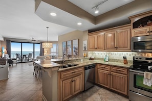A modern kitchen with granite countertops, stainless steel appliances, and wooden cabinets.