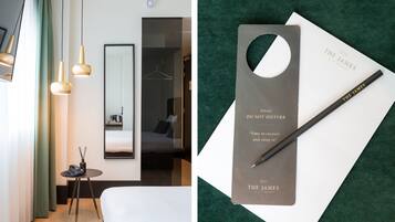 Una habitación de hotel moderna con cama, mesita de noche y espejo.
