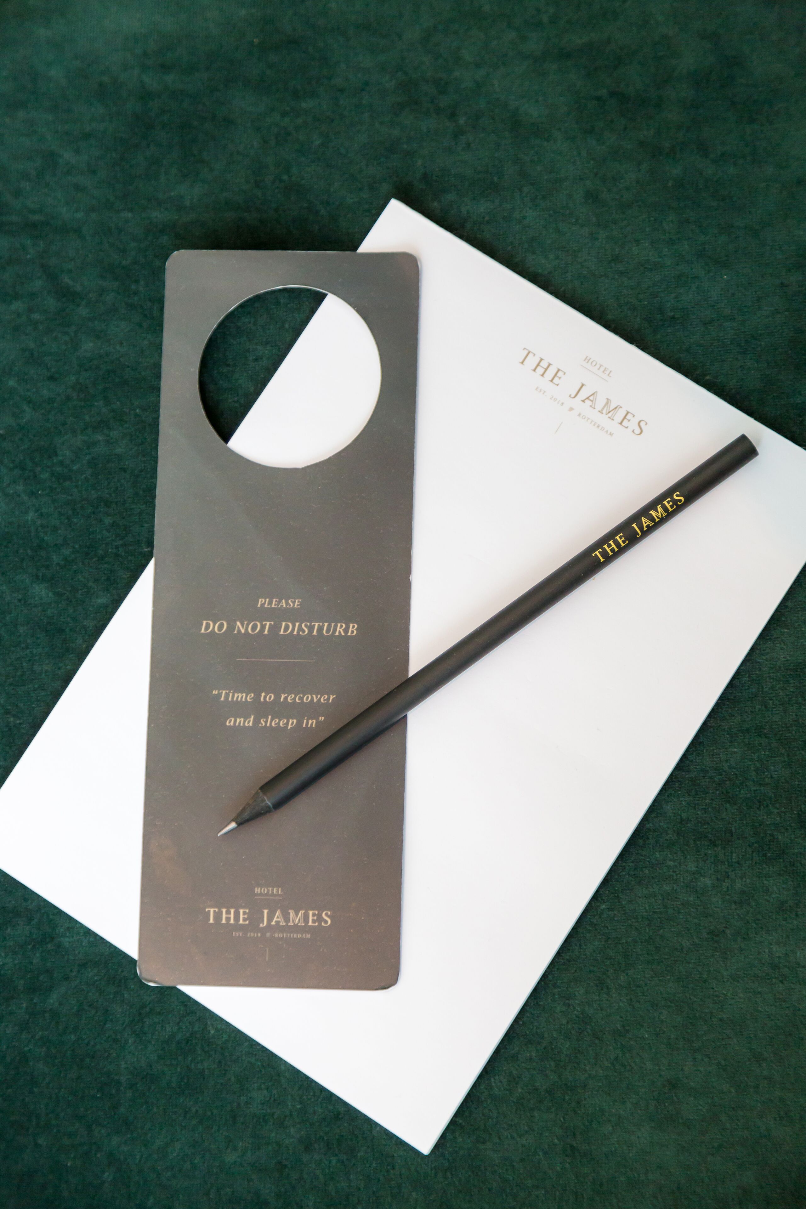 Une pancarte d’hôtel avec l’inscription « Veuillez ne pas déranger » et un crayon.