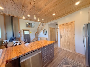 A kitchen with wooden ceiling, a central island, a refrigerator, and a stove. - The Cedars Country Cottage (Blanding)