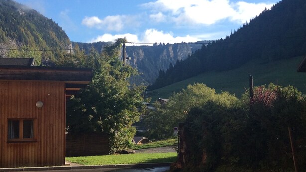 Ein Landweg, der zu einem Holthaus mit Tür und Fenster führt.