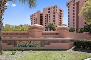 A multi-story building with balconies and a sign reading "SeaChase".