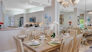 A spacious dining area with a wooden table set for a meal, surrounded by chairs. - **SUNSET POINT @ SUNSET MARINA** Condo / Pool + Last Key White Glove Service... (Key West)