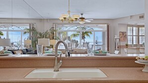 A modern kitchen with a large island, a sink, and a view of the ocean. - **SUNSET POINT @ SUNSET MARINA** Condo / Pool + Last Key White Glove Service... (Key West)