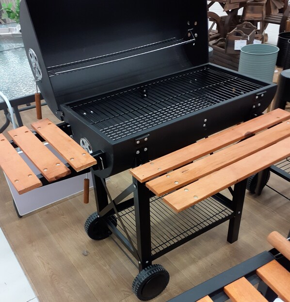 A portable barbecue grill with a metal grate, wheels, and wooden benches. - Villa Valia Seaside (Exclusive beach access Villa-Ipsos bay Corfu) (Ipsos)
