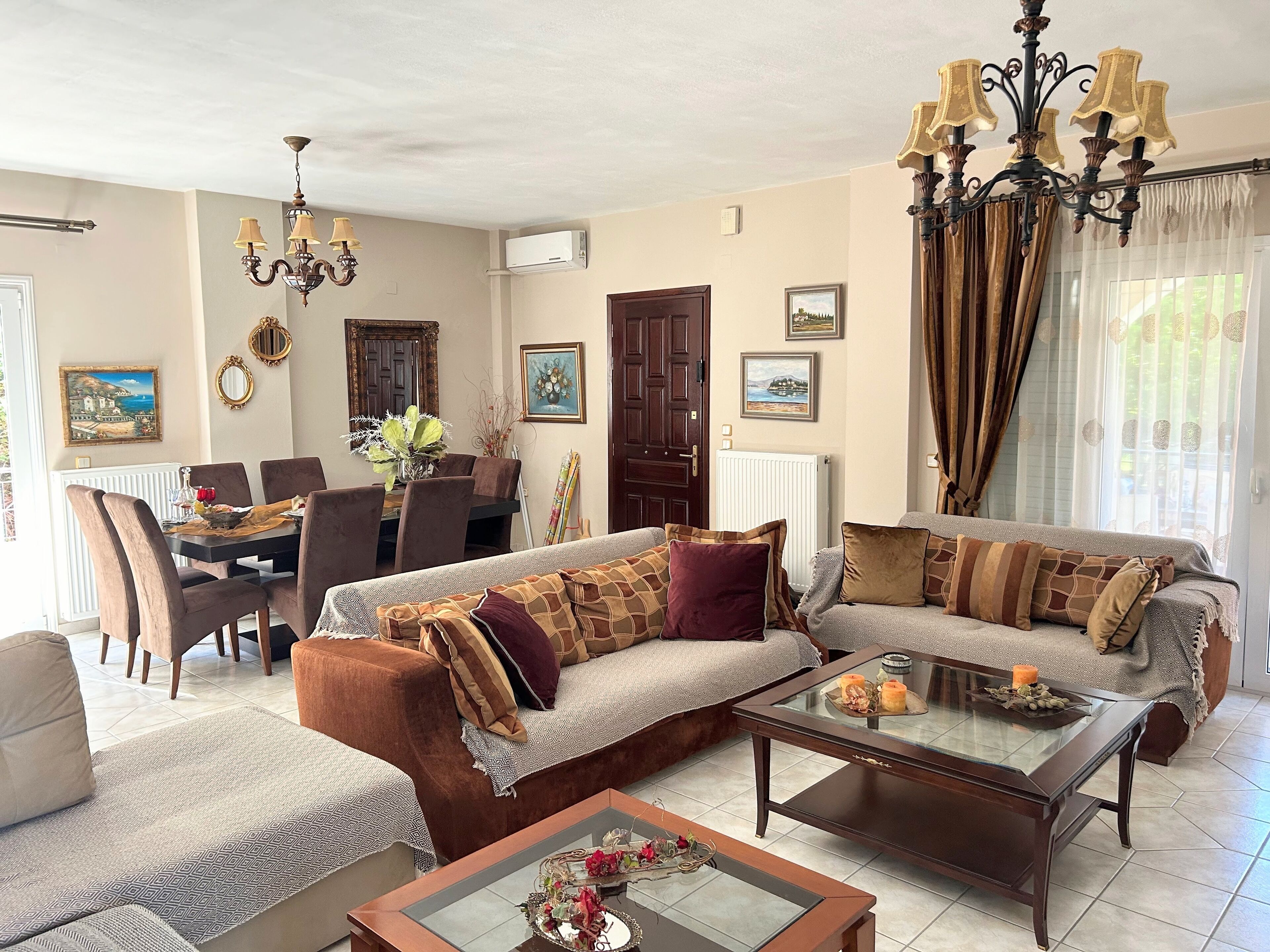 Un salon comprenant un canapé, des fauteuils, une table basse et un coin repas avec une table et des chaises.