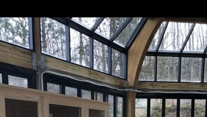 Une véranda avec un jacuzzi, des meubles en bois et une vue sur la forêt.