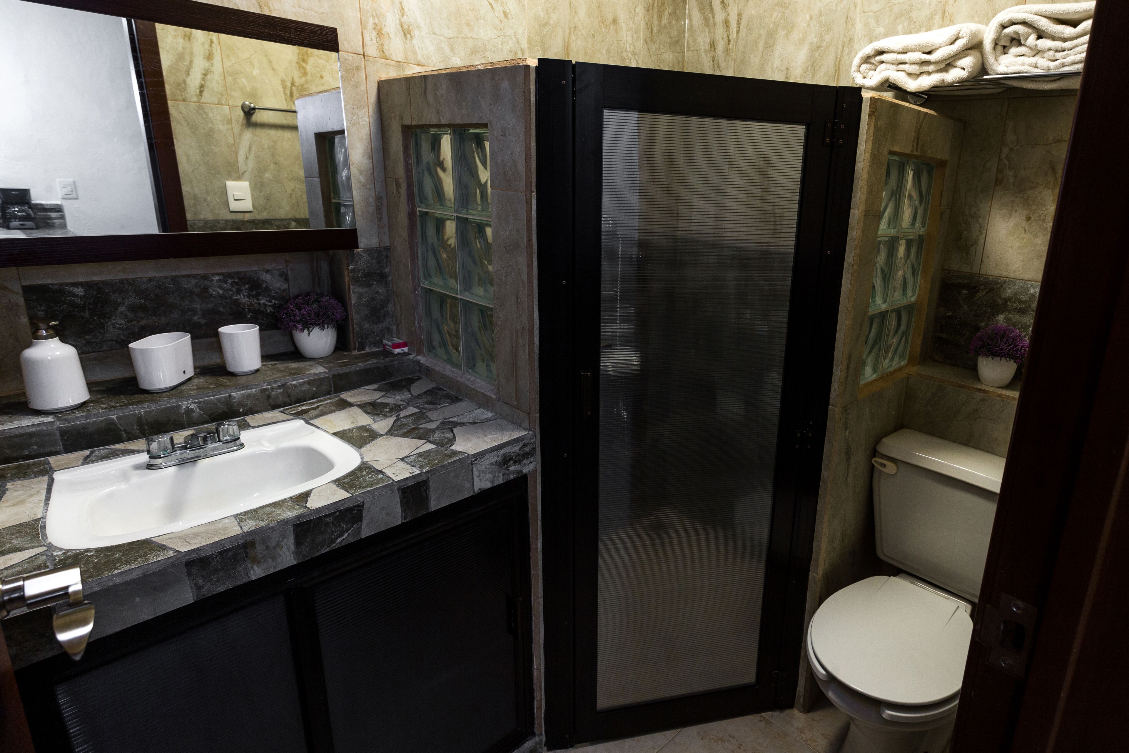 A bathroom with a sink, mirror, and toilet.