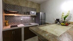 Una cocina moderna con microondas integrado, refrigerador y un lavamanos.