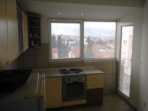 Enjoy cooking in this well-equipped kitchen with a gas stove, oven, and cabinetry.