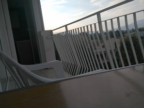 Enjoy the view from this balcony overlooking a residential area with houses and trees.