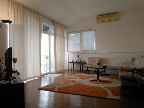 Relax in this stylish living room with a sofa, coffee table, and large window.