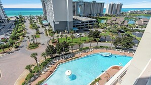 Ein Resort mit Schwimmbad, Palmen und Blick auf den Ozean.