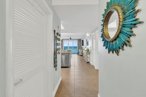 A hallway with a view to the ocean, a ceiling fan, and a decorative mirror. - Fabulous 2 BR condo! 2 Huge Pools! Fantastic Ocean Views! Great Location! (Miramar Beach)