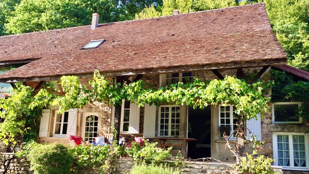 A rustic stone house with a tiled roof, a covered porch, and a garden area with grapevines. - Beautiful Village House (Chérizet)