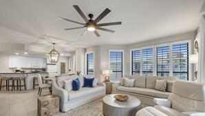 Un salon spacieux avec un grand canapé, une table basse et un ventilateur de plafond.