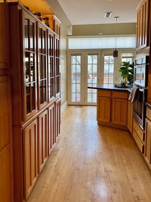 A kitchen with wooden cabinets, a central island, and a large window.