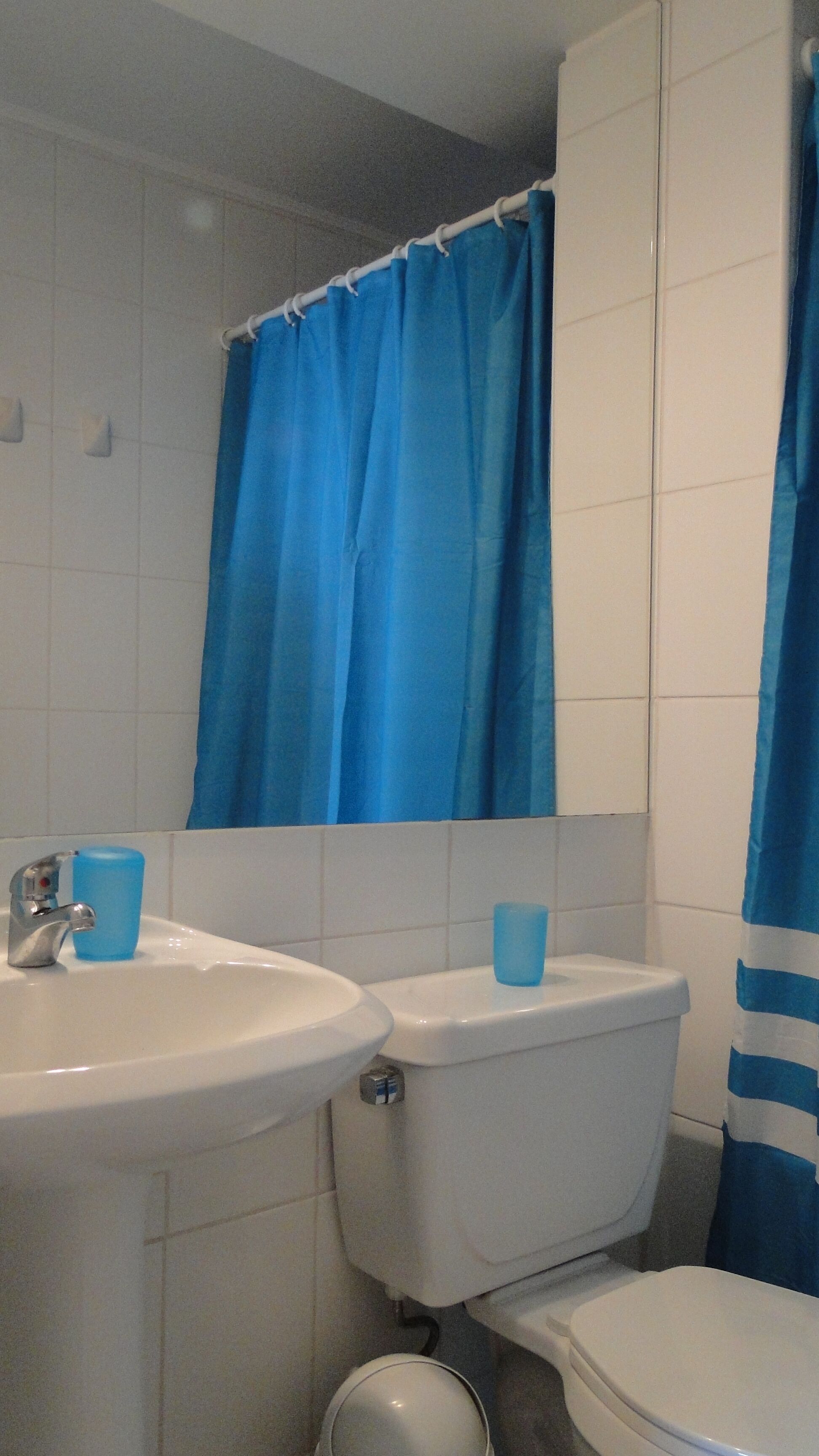 Een bad/douchecombinatie, handdoeken, zeep, shampoo