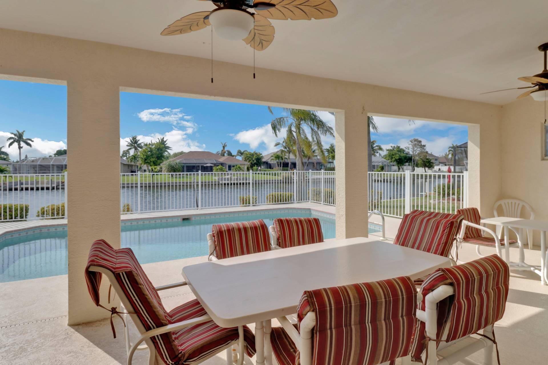 A spacious lanai, sundeck, fenced pool and canal view
