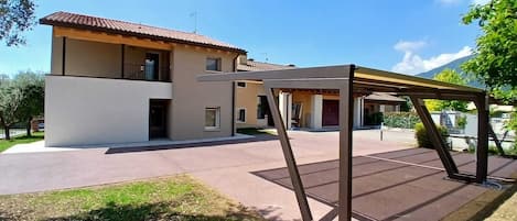 Une maison à deux étages dotée d’un patio et d’une pergola.