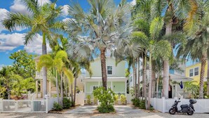 A residential area with a row of houses, palm trees, and a white picket fence. - **CAYO CALYPSO @ HIGGS BEACH** Home / Pool + Last Key White Glove Service... (Key West)