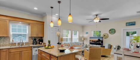A spacious kitchen with granite countertops, wooden cabinets, and a central island.