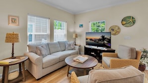A living room with a sofa, coffee table, TV, and decorative items. - **CAYO CALYPSO @ HIGGS BEACH** Home / Pool + Last Key White Glove Service... (Key West)