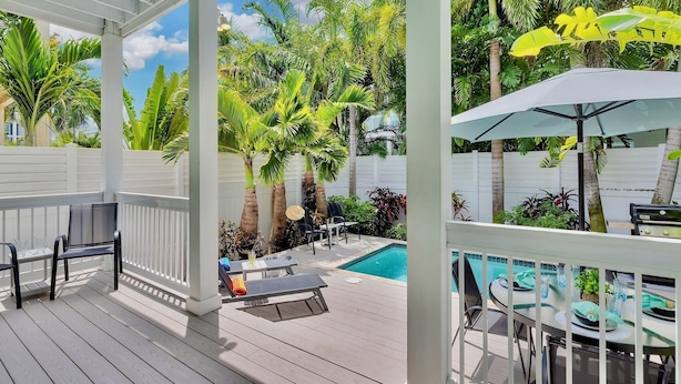 A covered outdoor area with a pool, lounge chairs, and a dining table. - **CAYO CALYPSO @ HIGGS BEACH** Home / Pool + Last Key White Glove Service... (Key West)