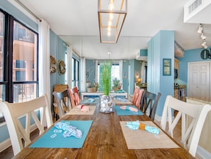 A dining area with a wooden table, chairs, and mats.