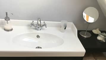 A bathroom with a white sink, black vanity, and a mirror.