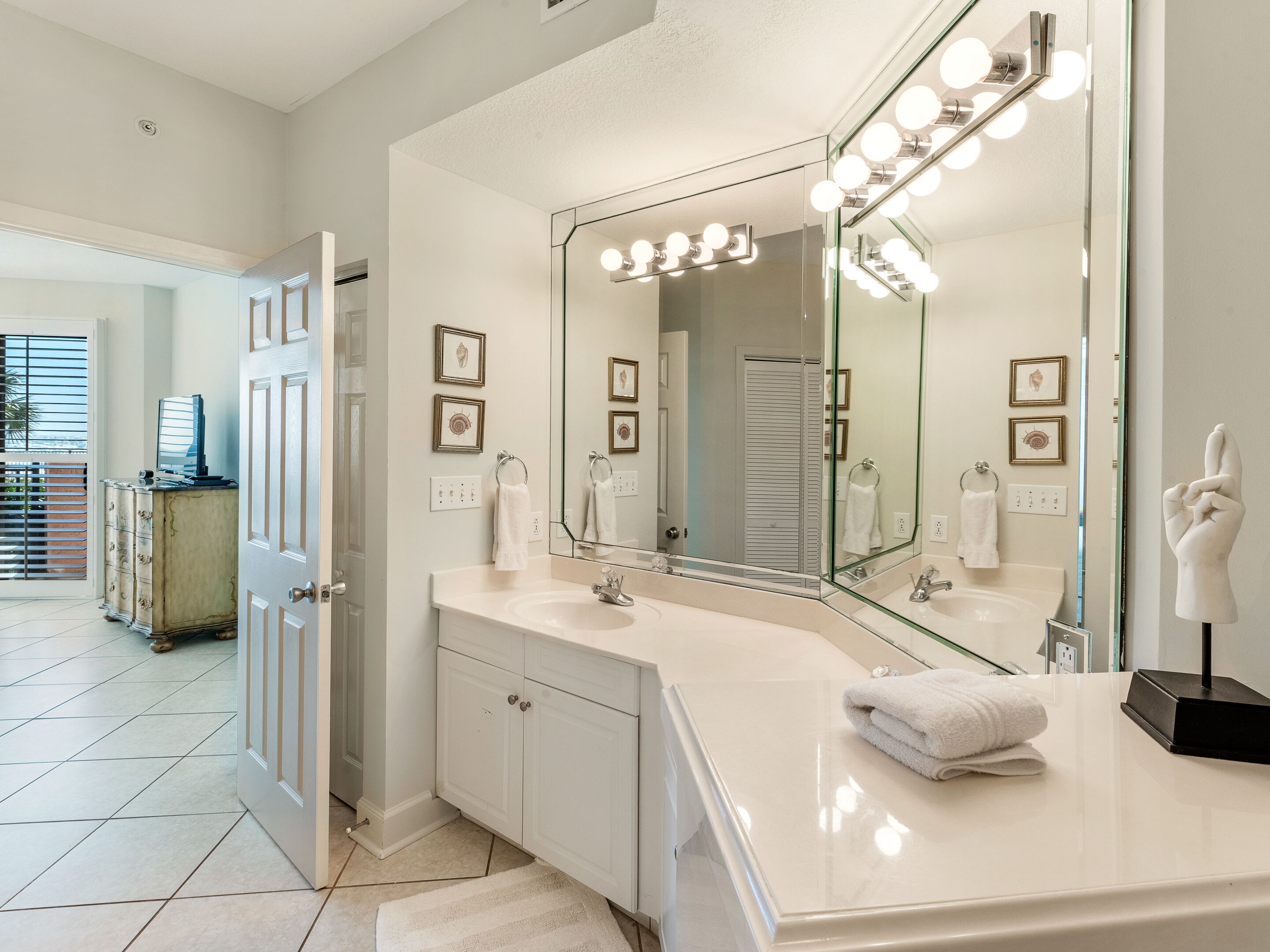 Une salle de bain avec un grand miroir, un meuble-lavabo et un porte-serviettes.