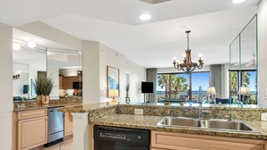 Een moderne keuken met granieten aanrechtbladen, roestvrijstalen apparatuur en een groot eiland.