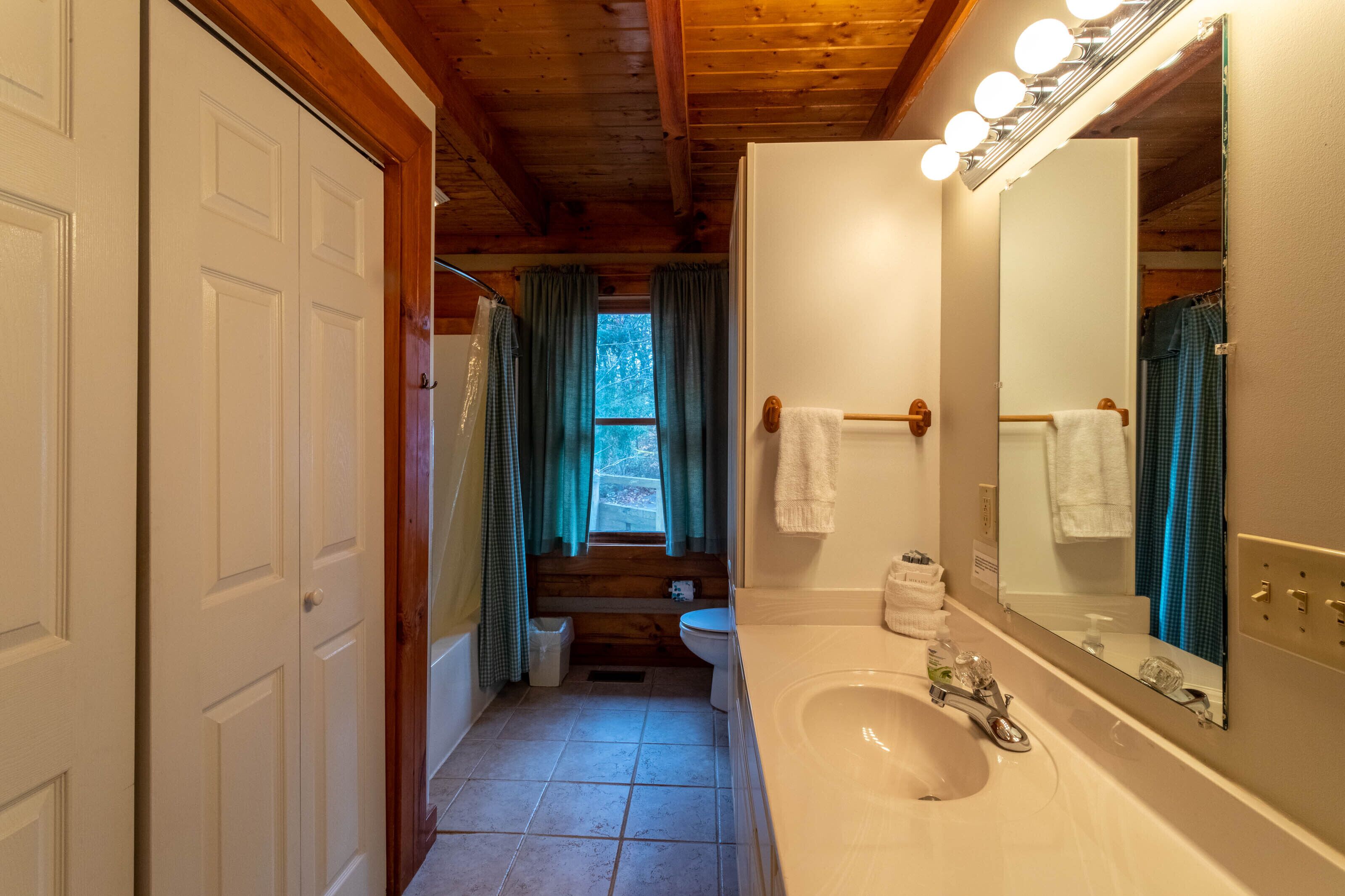 A bathroom with a sink, mirror, and towel rack.