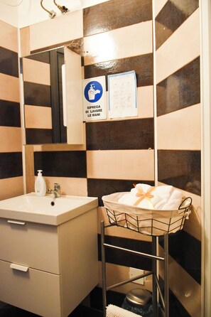 A bathroom with a sink, mirror, and towel rack.