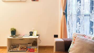 Relax in a serene space with a comfortable bed, a potted plant, and beautiful artwork.