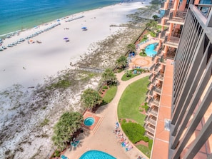 A resort with a beach, a pool, and a view of the ocean.