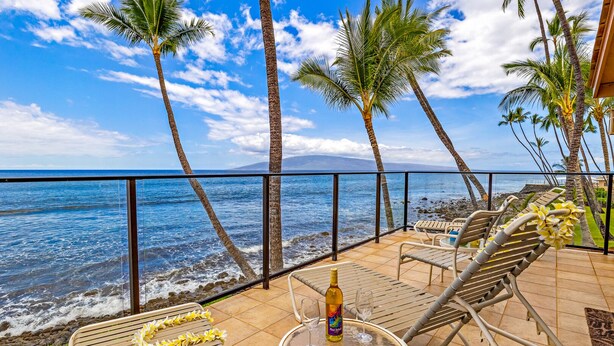 A terrace with a view of the ocean, palm trees, and lounge chairs. - Spectacular Maui Family vacation home - 4 bedroom + den, 4 bath, AC, pool. (Lahaina)