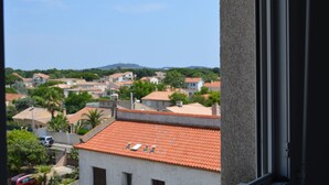Zona residencial con casas, algunas con tejados de tejas rojas, y un cielo azul despejado.