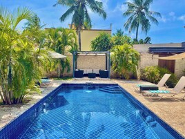 Una piscina al aire libre, sombrillas, tumbonas