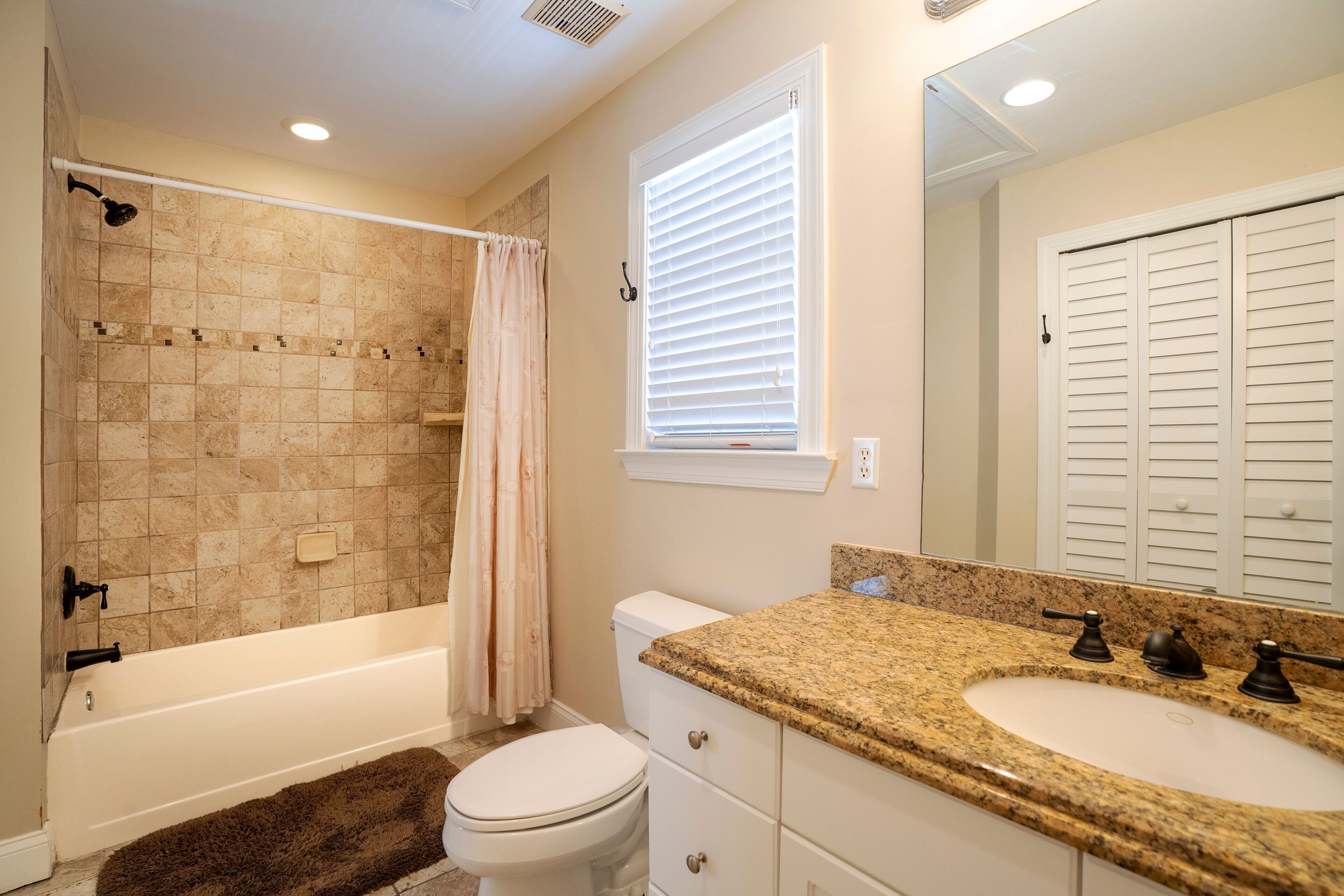 A bathroom with a bathtub, toilet, and sink.