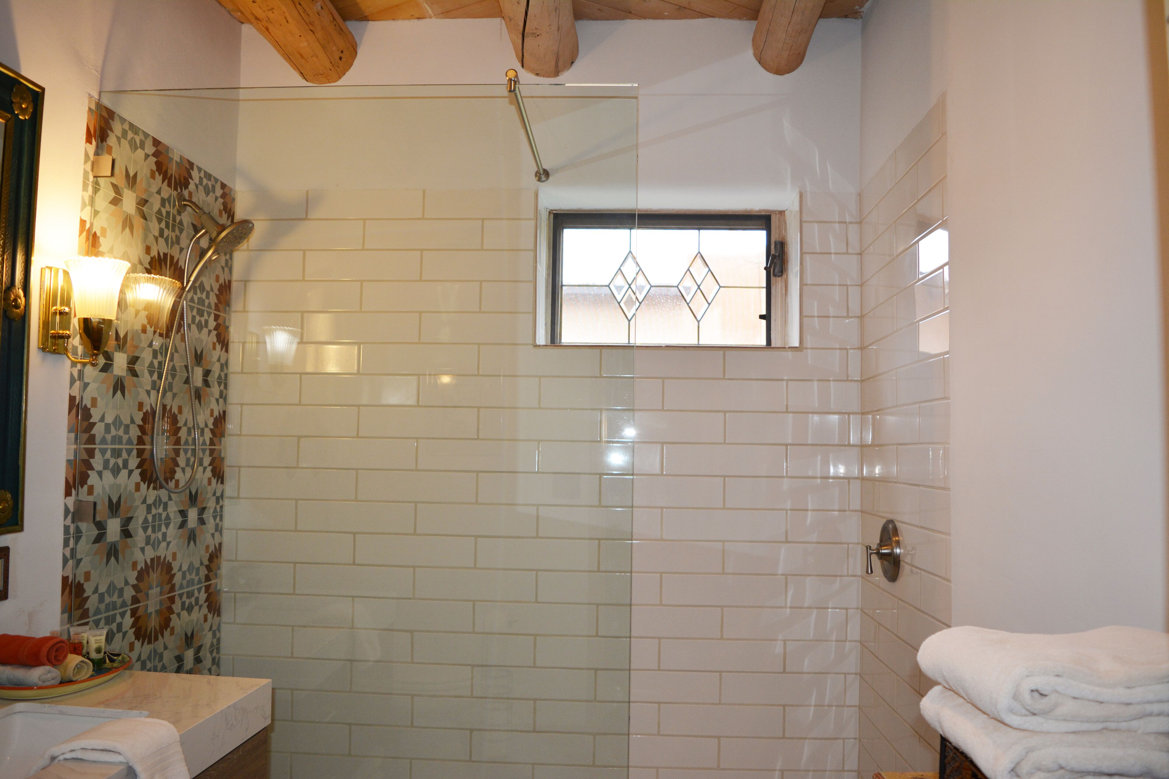Ein Badezimmer mit Dusche, Waschbecken und Fenster.