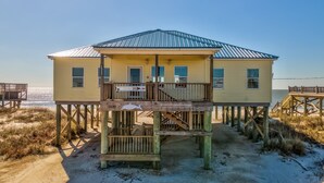 A two-story wooden beach house with a balcony, situated on stilts over the sand. - Sunset Blvd | Unmatched Ocean Views from private pool (Dauphin Island)