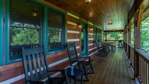 A covered porch with wooden railings, rocking chairs, and a view of trees. - A Positive Outlook -10 mins to ASU, Hot Tub - Pool Table - Corner Jacuzzi (Vilas)