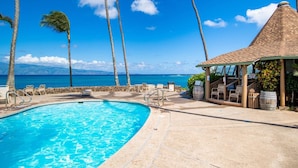 A swimming pool with lounge chairs, a covered seating area, and a view of the ocean. - Napili Shores I-269 - Direct Oceanfront:  Summer and Fall Savings!  Free Activities! (Napili)