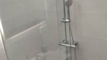 Een bad/douchecombinatie, een haardroger, een bidet, handdoeken