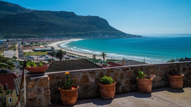 A coastal view with a stone wall and potted plants. - Sea Cottage - House - spectacular sea views (Cape Town)