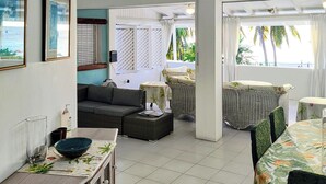 A spacious living area with a sofa, dining table, and a view of the outdoors.