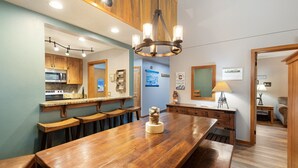 A spacious kitchen with wooden cabinets, a large wooden table, and a chandelier. - Spacious Updated Retreat/Sleeps 14/On Shuttle Route/Pool and Hot Tub Access (Keystone)